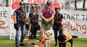 Participants in Central Park Plunge pose with Ambassador Dogs Annie and Eva
