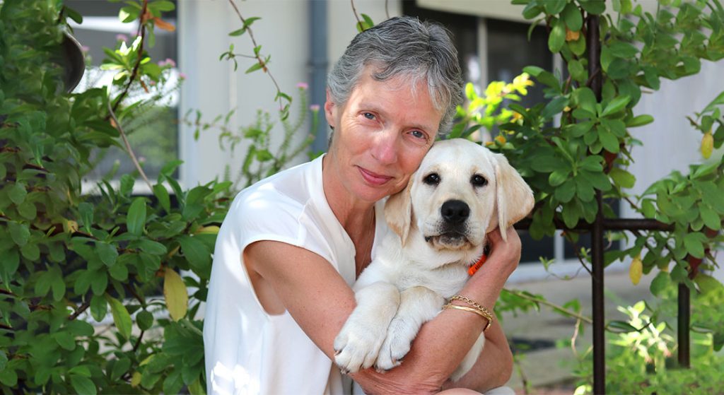 CEO Elizabeth Barnes with yellow labrador puppy