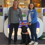 Guide Dogs WA staff member and Cancer Council WA staff member standing in shopping centre with Ambassador Dog.