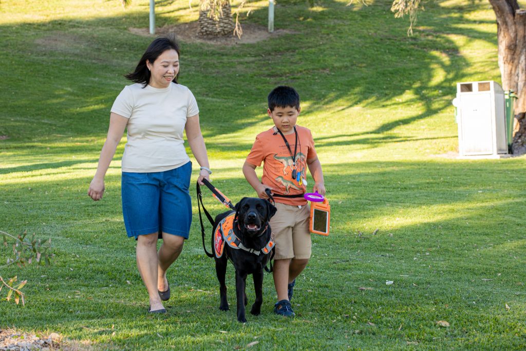Woman walking with dog and son in the park.