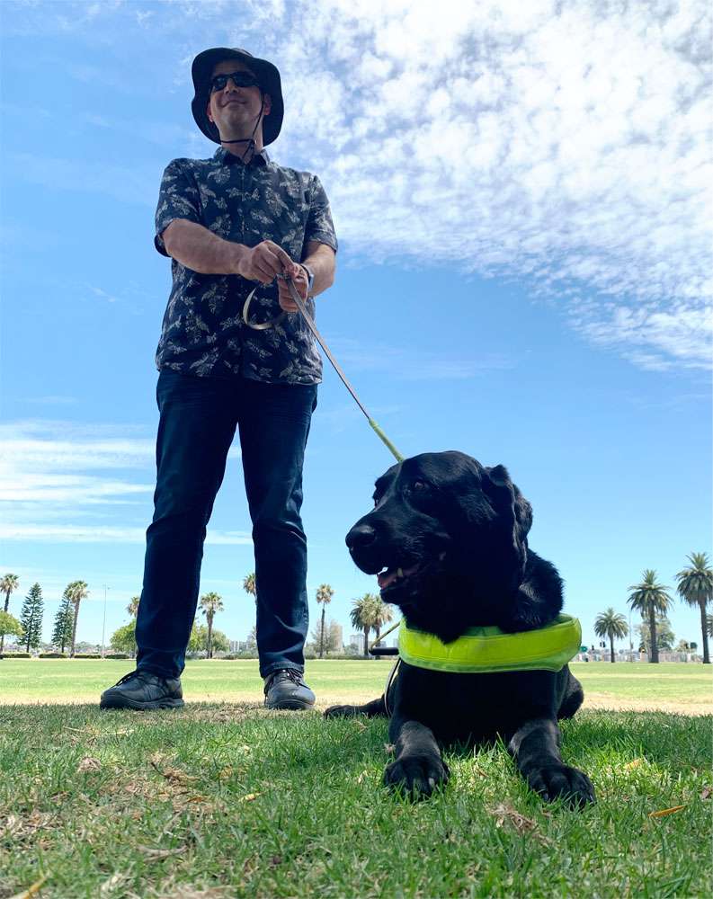 Guide Dog Handler and Guide Dog outside on the grass