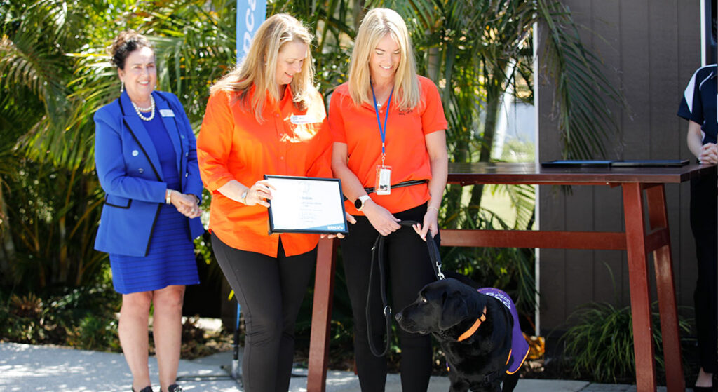 Chief Executive Officer Anna and Instructor Katie with Facility Dog Winston receiving his award.