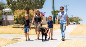 Family walking along footpath with Autism Assistance Dog.